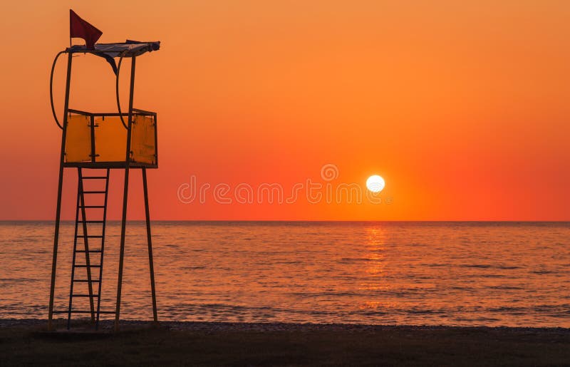Lifeguard rescue tower on beach at sunset royalty free stock images