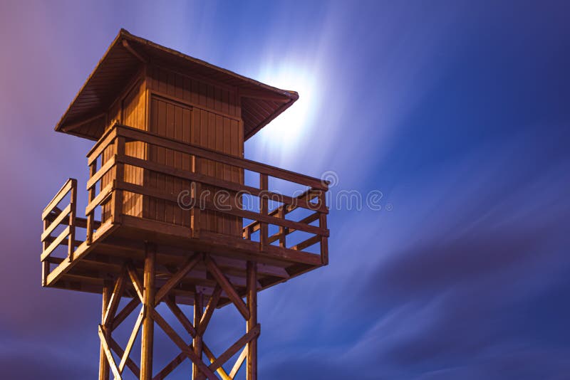 Lifeguard tower under the moonlight. Wooden lifeguard tower at night. Wooden structure in a European beach. Lifeguard hut