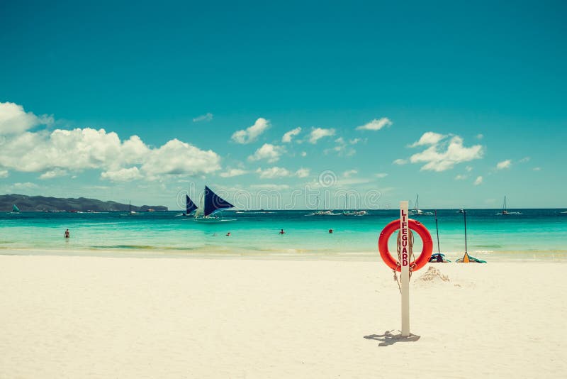 Lifesaver equipment on tropical white sand paradise beach. Red lifebuoy. Life insurance helping concept. Travel to Philippines. Boracay seascape. Water activities. Luxury holiday resort. Copy space. Lifesaver equipment on tropical white sand paradise beach. Red lifebuoy. Life insurance helping concept. Travel to Philippines. Boracay seascape. Water activities. Luxury holiday resort. Copy space