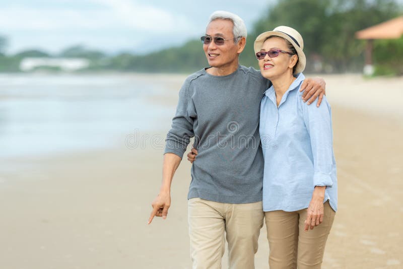 Lifestyle asian senior couple happy walking and relax on the beach.  Tourism elderly family travel leisure and activity after retirement in vacations and summer. Lifestyle asian senior couple happy walking and relax on the beach.  Tourism elderly family travel leisure and activity after retirement in vacations and summer