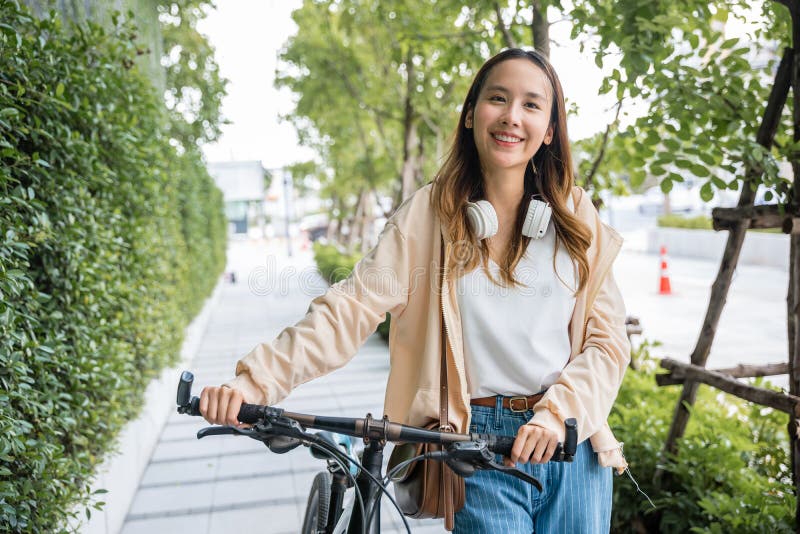 Lifestyle Asian young woman walking alongside with bicycle on summer in countryside outdoor