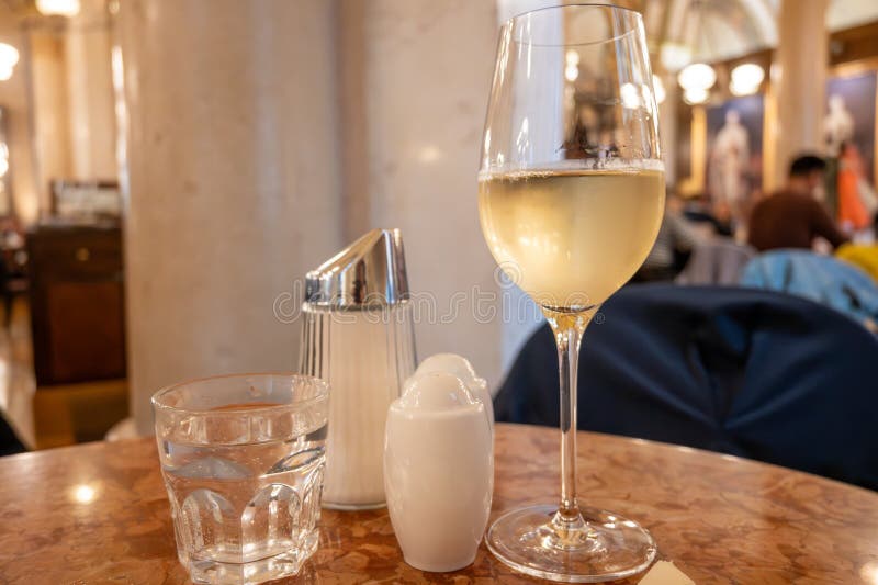 Lifestyle of beautiful Vienna, glass of cold white dry Austrian wine served in old Viennese-style cafe in Vienna, Austria royalty free stock images