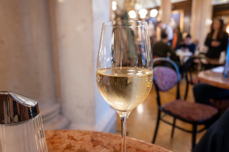 Lifestyle of beautiful Vienna, glass of cold white dry Austrian wine served in old Viennese-style cafe in Vienna, Austria royalty free stock images