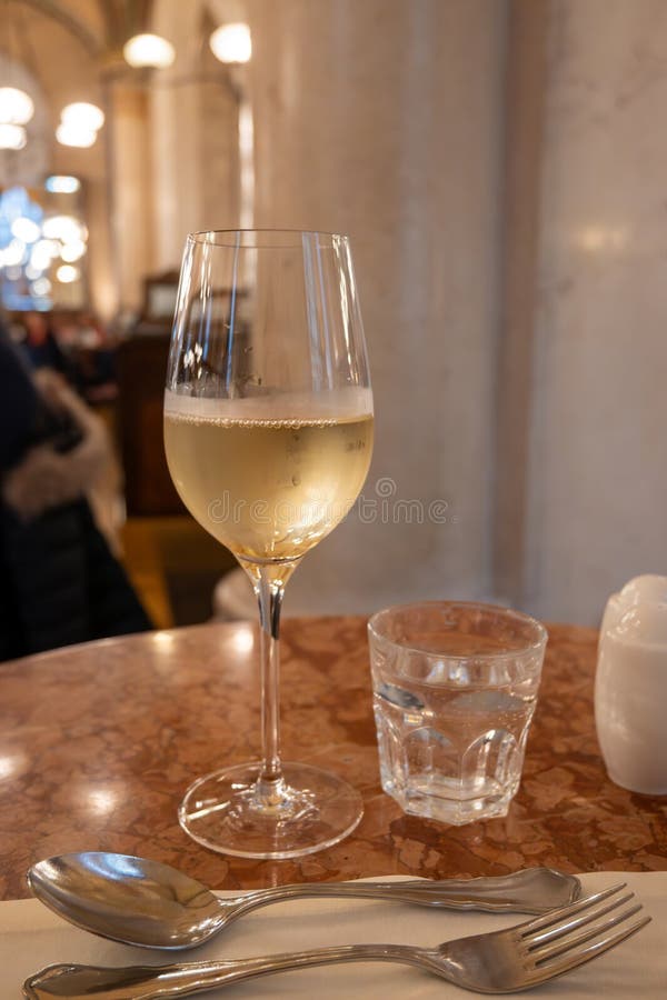 Lifestyle of beautiful Vienna, glass of cold white dry Austrian wine served in old Viennese-style cafe in Vienna, Austria royalty free stock photo