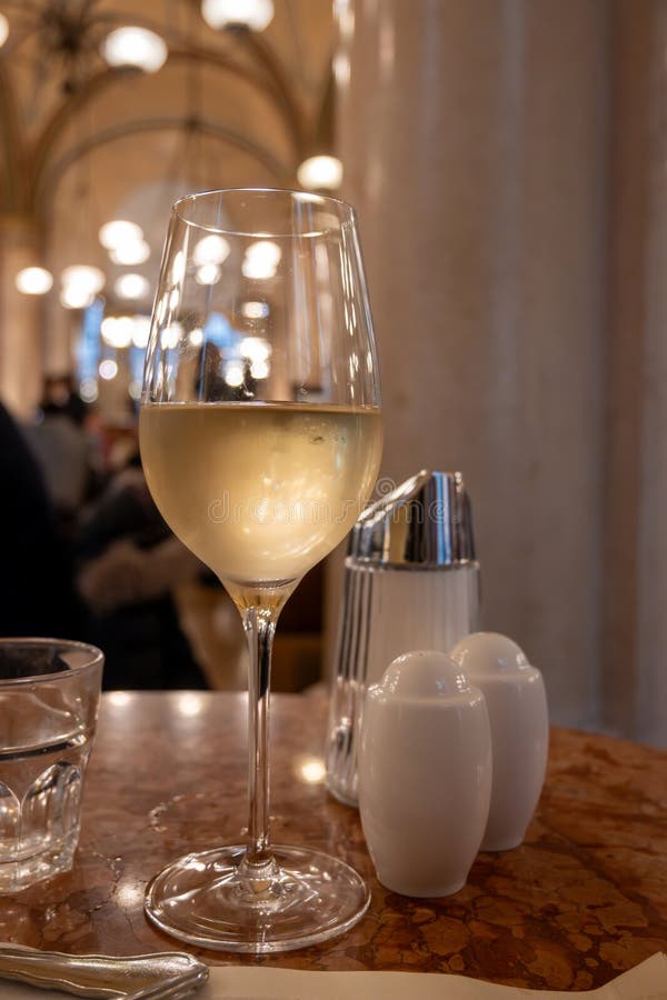 Lifestyle of beautiful Vienna, glass of cold white dry Austrian wine served in old Viennese-style cafe in Vienna, Austria stock image