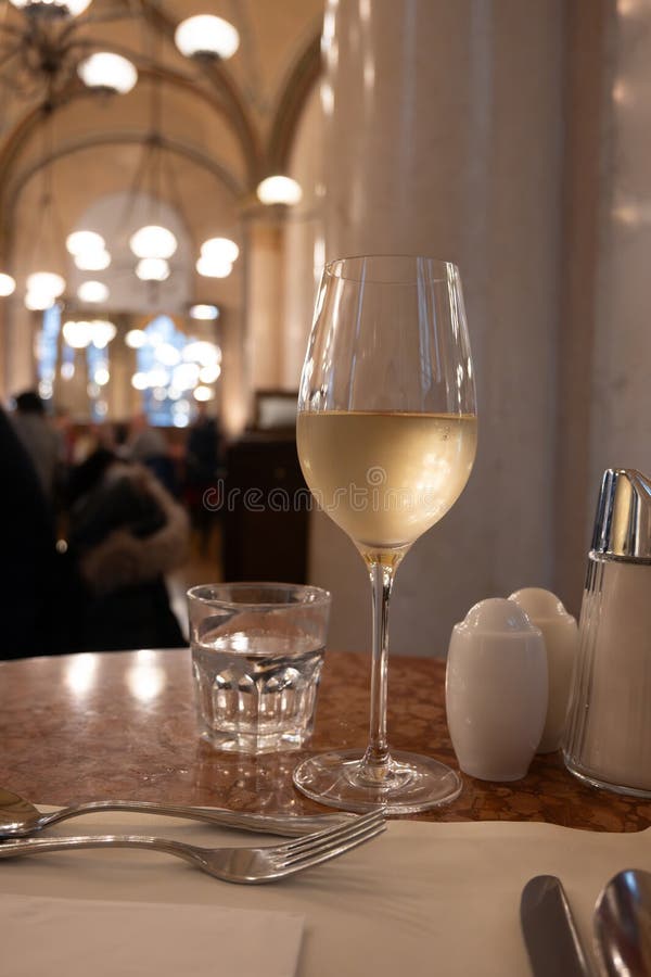 Lifestyle of beautiful Vienna, glass of cold white dry Austrian wine served in old Viennese-style cafe in Vienna, Austria royalty free stock image