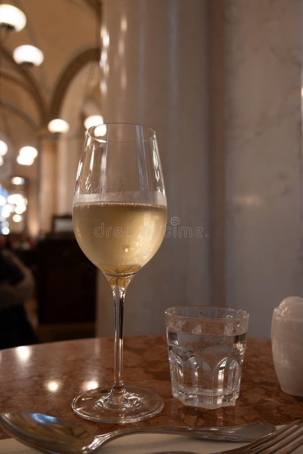 Lifestyle of beautiful Vienna, glass of cold white dry Austrian wine served in old Viennese-style cafe in Vienna, Austria stock images