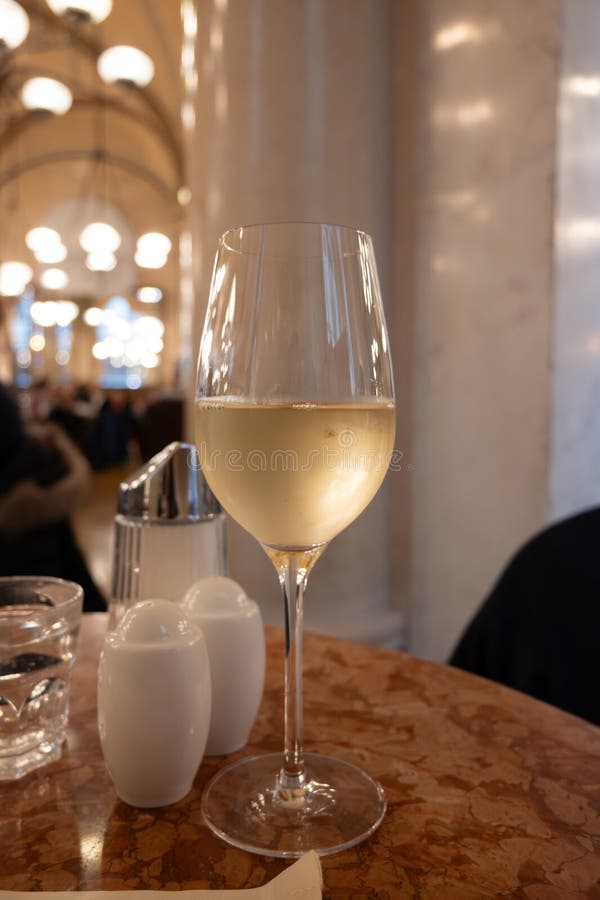 Lifestyle of beautiful Vienna, glass of cold white dry Austrian wine served in old Viennese-style cafe in Vienna, Austria royalty free stock photo