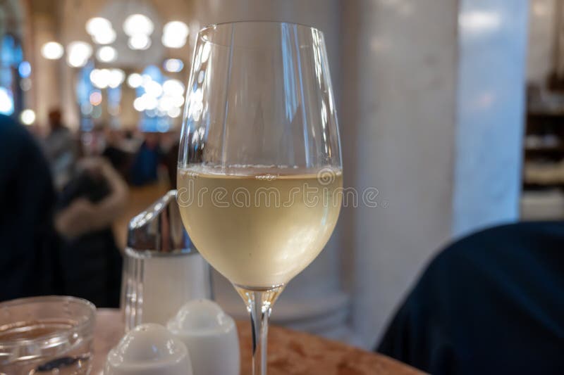Lifestyle of beautiful Vienna, glass of cold white dry Austrian wine served in old Viennese-style cafe in Vienna, Austria royalty free stock photos
