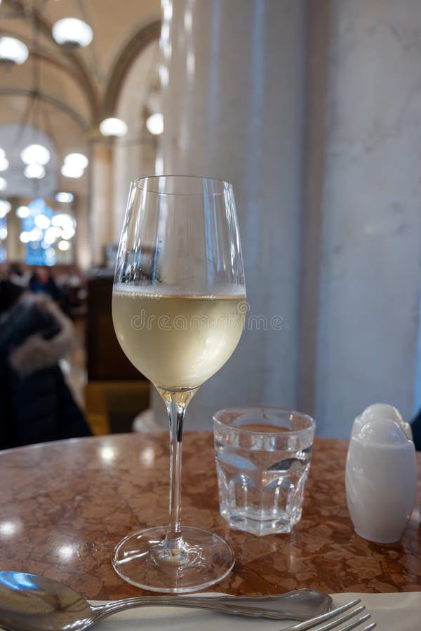 Lifestyle of beautiful Vienna, glass of cold white dry Austrian wine served in old Viennese-style cafe in Vienna, Austria royalty free stock photo