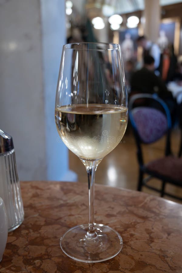 Lifestyle of beautiful Vienna, glass of cold white dry Austrian wine served in old Viennese-style cafe in Vienna, Austria royalty free stock photography