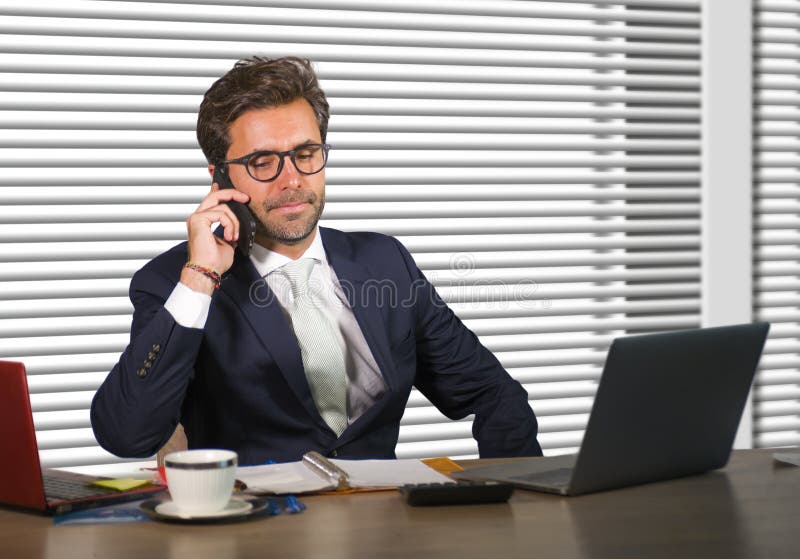 Lifestyle corporate company portrait of young happy and busy business man working at modern office talking on mobile phone by wind royalty free stock images Lifestyle corporate company portrait of young happy and busy business man working at modern office talking on mobile phone by wind royalty free stock images