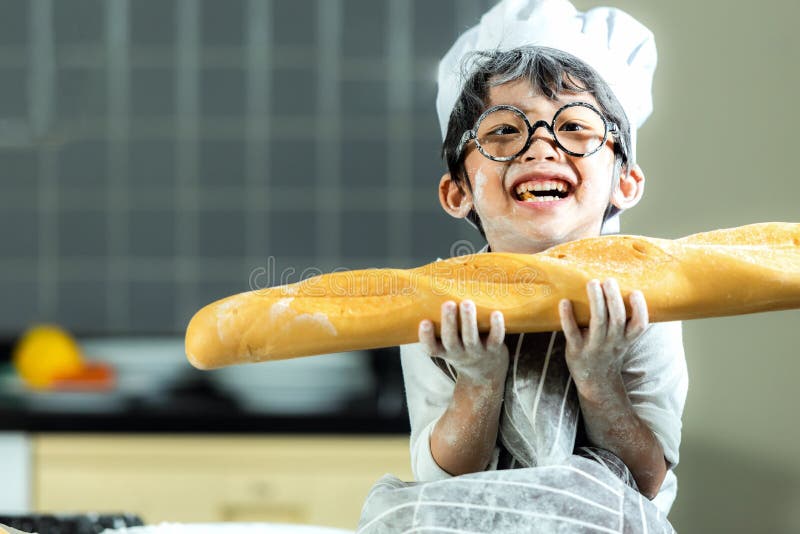 Lifestyle Family. Smiling chef asian kid boy cooking toast and make bread for dinner. People children making and leaning sweet f royalty free stock photo Lifestyle Family. Smiling chef asian kid boy cooking toast and make bread for dinner. People children making and leaning sweet f royalty free stock photo