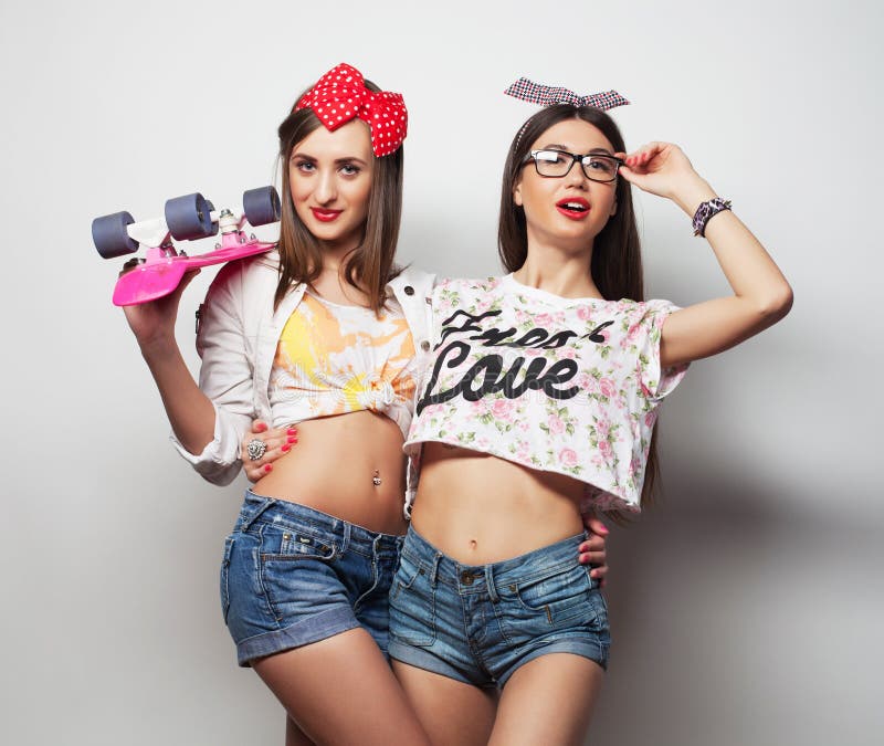 Lifestyle, friendship and people concept: Two young girl friends standing together and having fun. stock photo Lifestyle, friendship and people concept: Two young girl friends standing together and having fun. stock photo