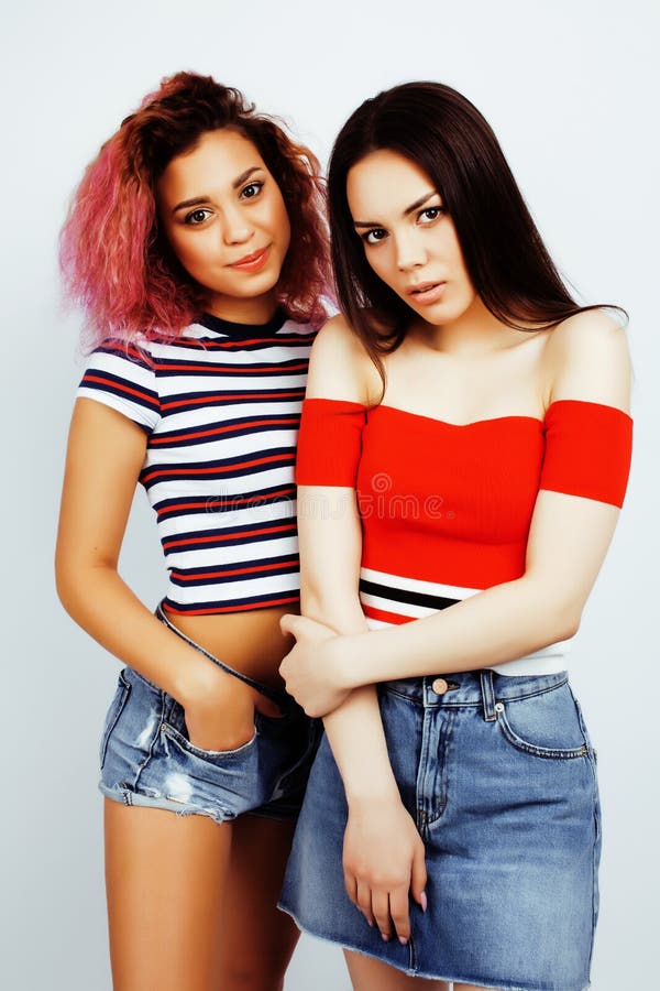 Lifestyle people concept: two pretty stylish modern hipster teen girl having fun together, diverse nation mixed races