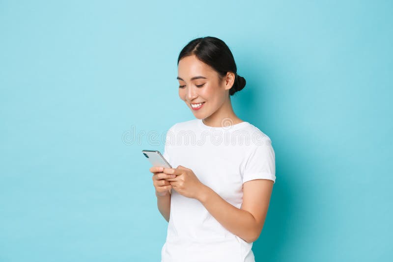 Lifestyle, technology and e-commerce concept. Side view of attractive asian girl using mobile phone, texting, messaging