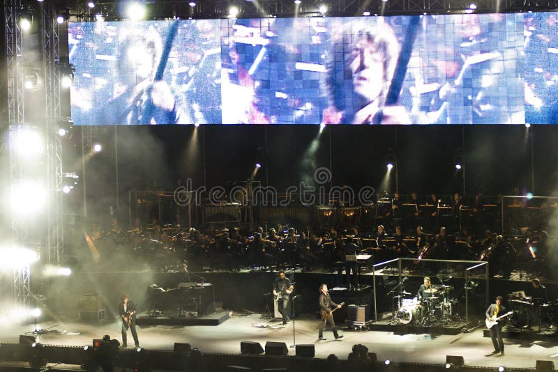Ligabue singing and playing guitar with his band with a hudge TV screen during one of his concert in arena di Verona - Italy 2007. Ligabue singing and playing guitar with his band with a hudge TV screen during one of his concert in arena di Verona - Italy 2007