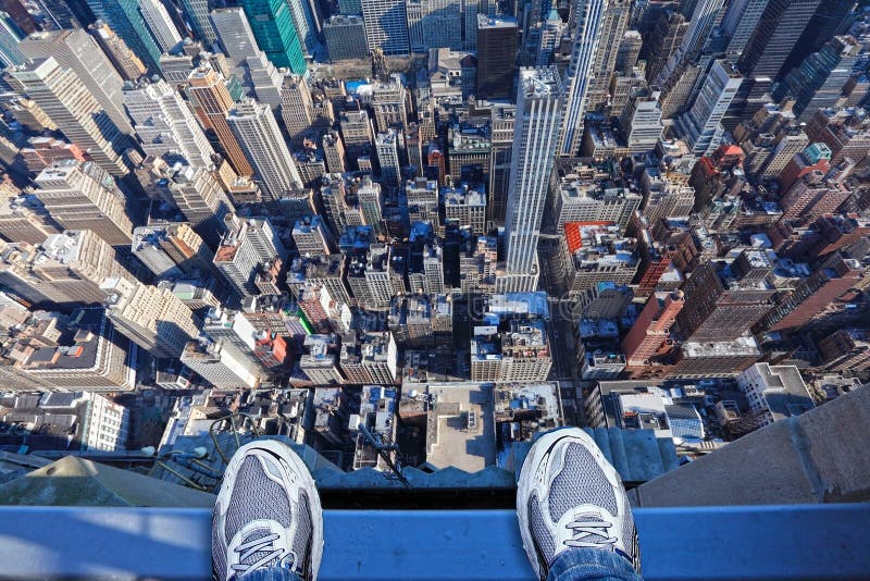 Jumpers feet on the edge of a very tall building thinking of committing suicide, depression, stress concept. Empire State building. New York City. Jumpers feet on the edge of a very tall building thinking of committing suicide, depression, stress concept. Empire State building. New York City.