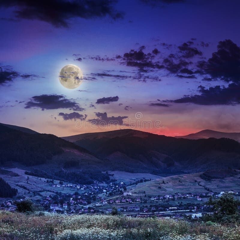 Light beam falls on hillside with autumn village in mountain at