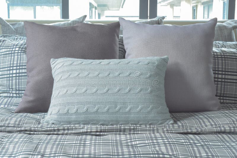 Light Blue and Gray Pillows on Cross Pattern Bedding Stock Photo