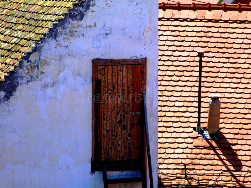 sloped clay roof ridge. red roof tiles and yellow attic