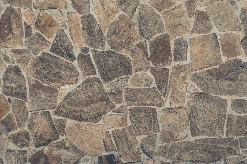 Light brown stone wall background. Light brown textural background from stone mosaic. Light brown stone wall in abstract style. Te stock images