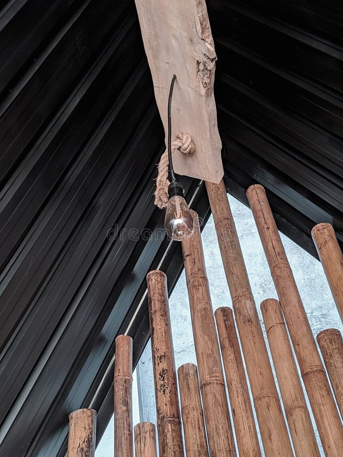 A Light Bulb Hanging on the Roof of a Wooden Building Stock Image