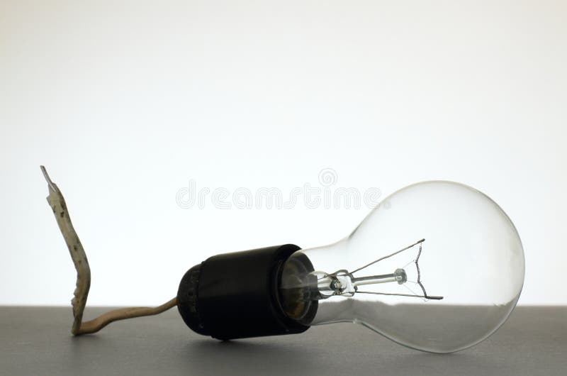 Light bulb installed into grubby lamp socket royalty free stock photography