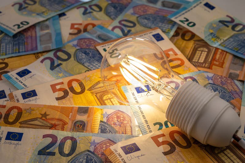 Light bulb on, on top of banknotes. stock photo