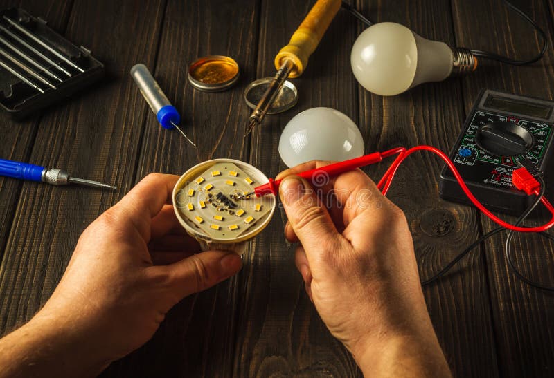 Light Bulb Repair at Home Using a Tester or in a Service. Hands of the