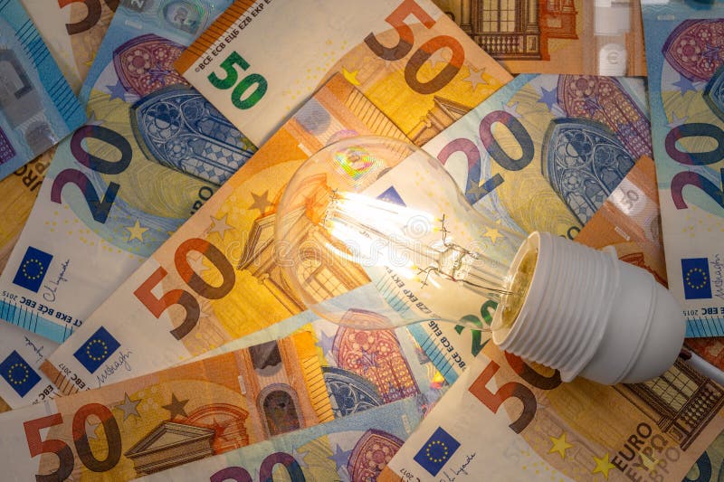 Light bulb on, on top of banknotes. royalty free stock photography