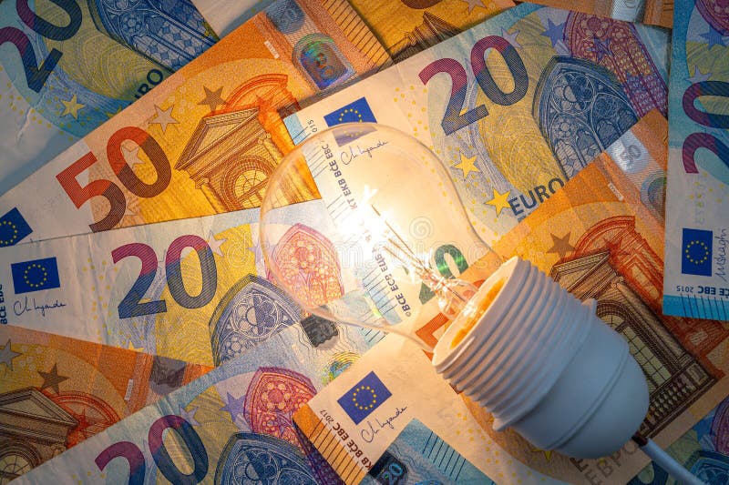 Light bulb on, on top of banknotes. royalty free stock image