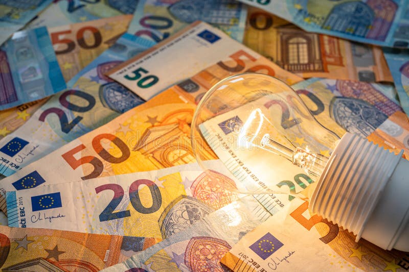 Light bulb on, on top of banknotes. stock photos