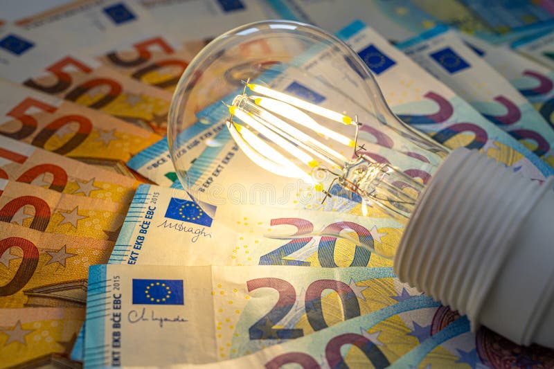 Light bulb on, on top of banknotes. stock photo