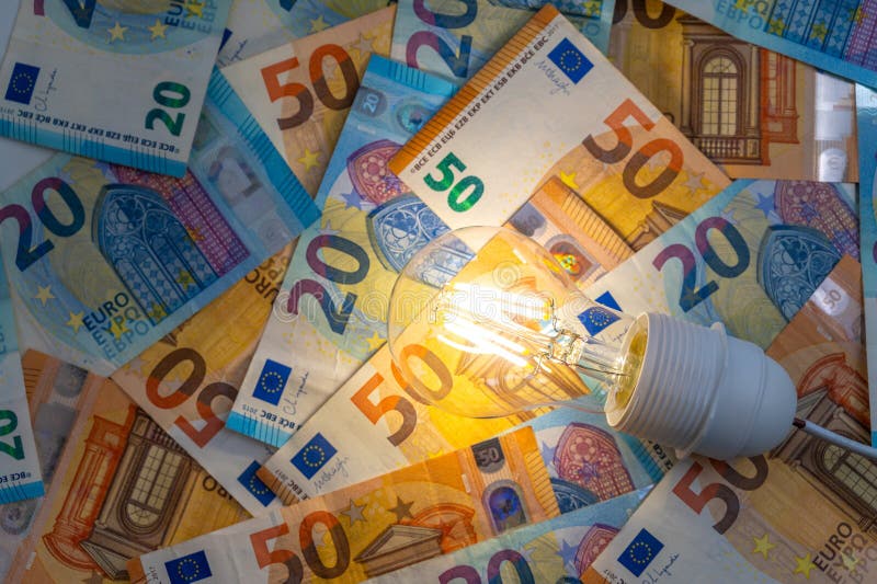 Light bulb on, on top of banknotes. royalty free stock images