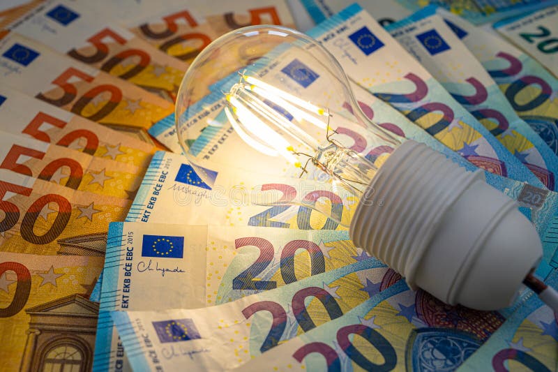 Light bulb on, on top of banknotes. royalty free stock images
