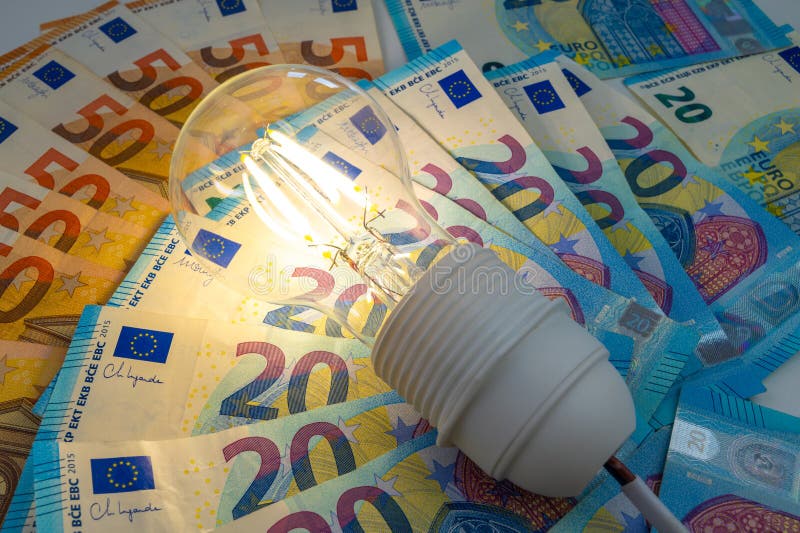 Light bulb on, on top of banknotes. stock images