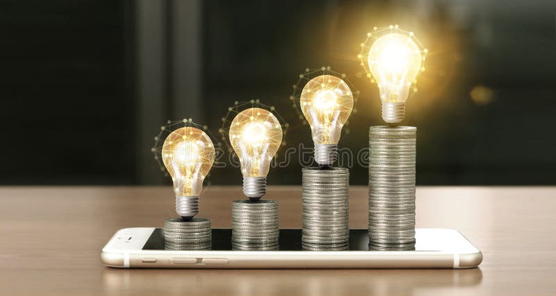 Light bulb on top of coins and smartphone royalty free stock photography