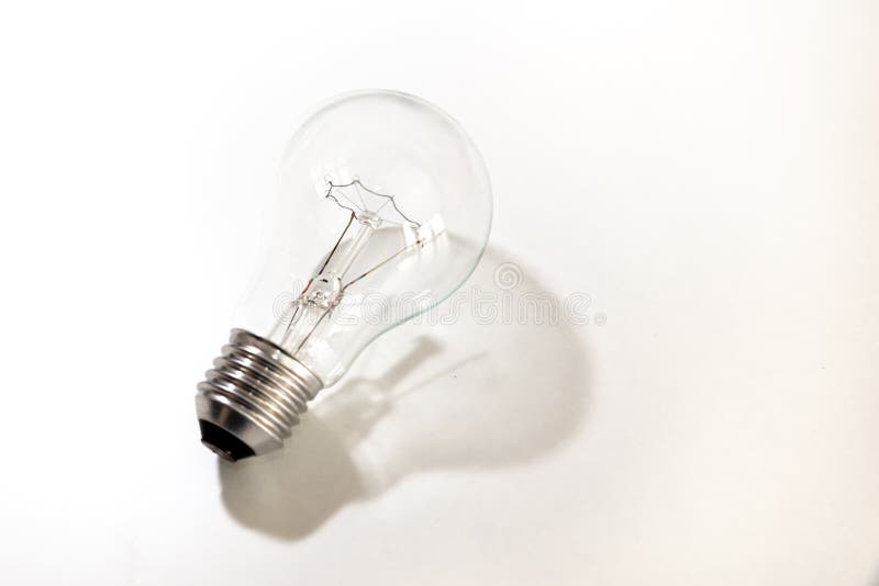 Light bulb turned off, on white surface. Shadow of the light bulb. royalty free stock photo
