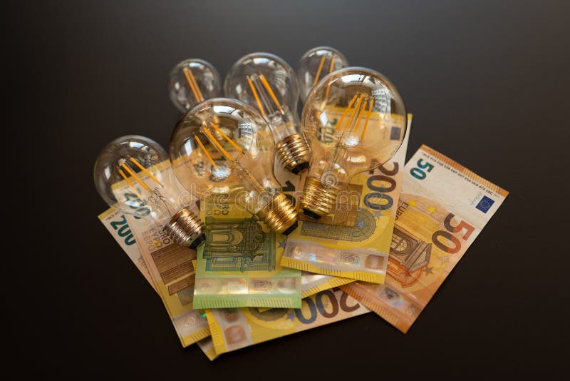 Light Bulbs Set and Euro Banknotes on a Black Background.Crisis in the