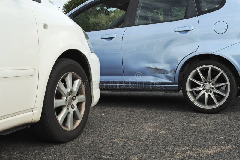 Modré a biele autá zastavili vo svetle nehody tak, dvere modré auto je ohnutá, farba je poškriabaný a potrebuje opravu.