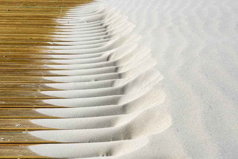 Light fine beach sand brought by the wind on brown outdoor terrace boards royalty free stock photos