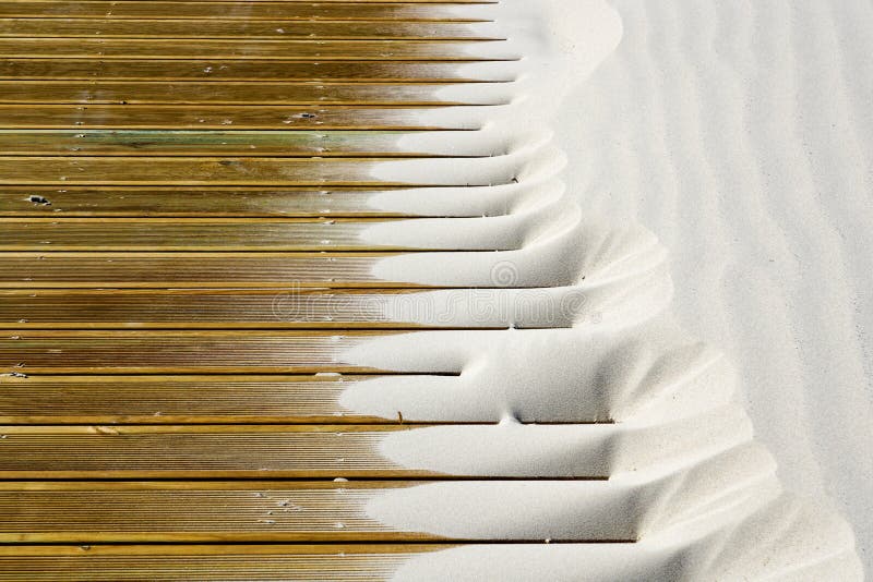 Light fine beach sand brought by the wind on brown outdoor terrace boards stock photos
