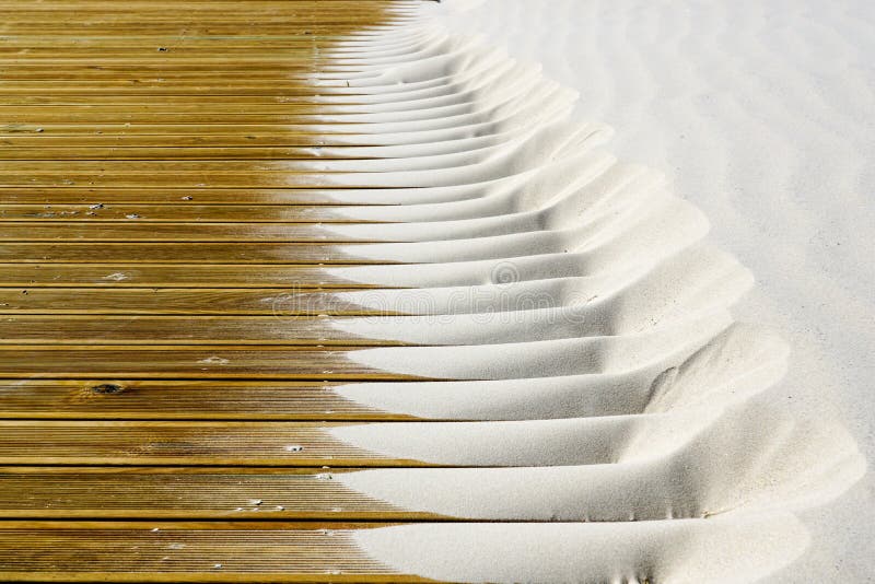 Light fine beach sand brought by the wind on brown outdoor terrace boards royalty free stock images