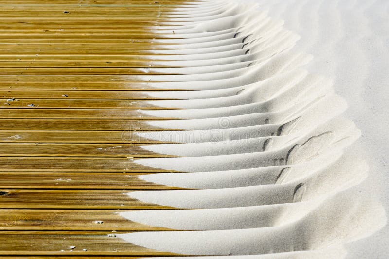 Light fine beach sand brought by the wind on brown outdoor terrace boards royalty free stock photo