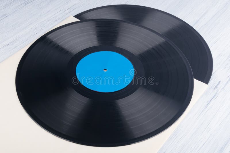 On a Light Gray Background, on a Paper Envelope, are Two Vinyl Records