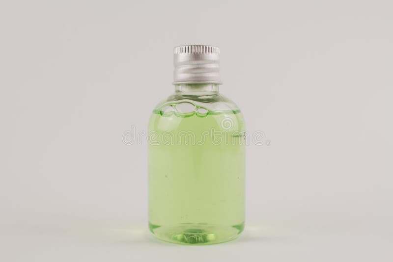 Light Green Shampoo in a Transparent Bottle on a White Background Stock
