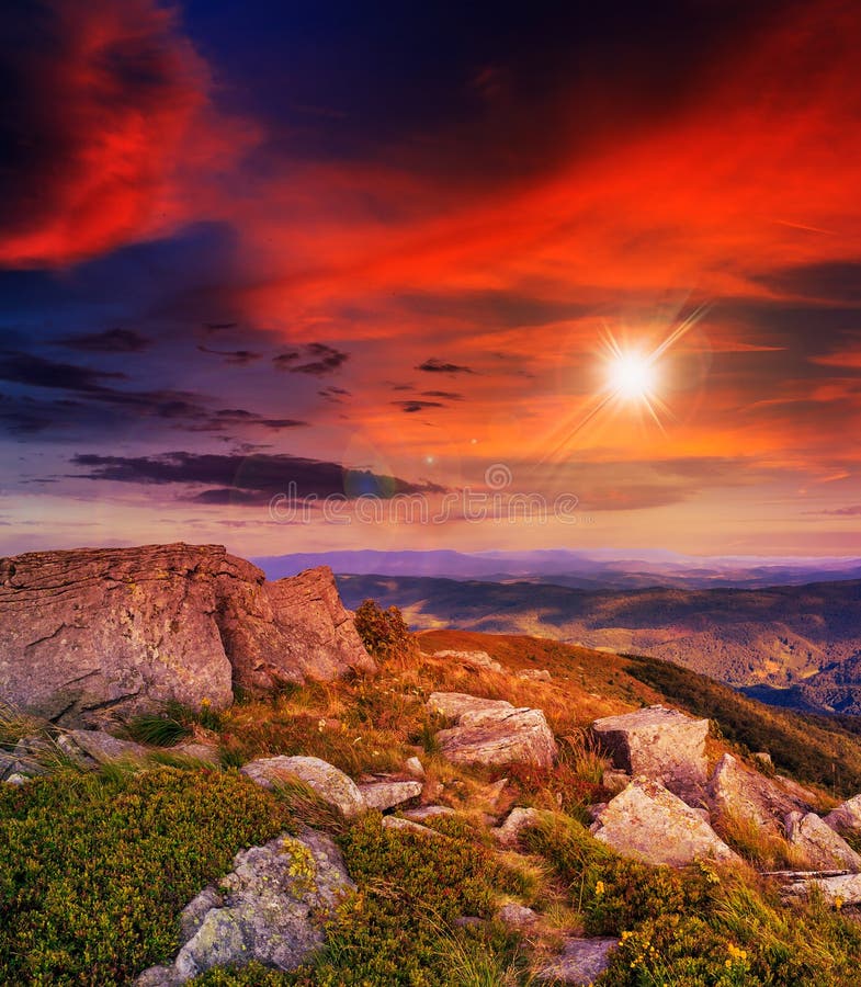 Light on stone mountain slope with forest at sunset