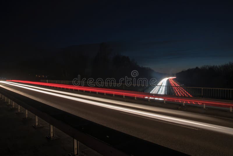 Light Trails of Cars at Night Driving on the Highway Stock Photo