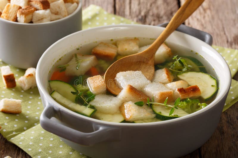 Light Vegetable Broth with Croutons and Thyme Closeup in a Saucepan. Horizontal Stock Photo
